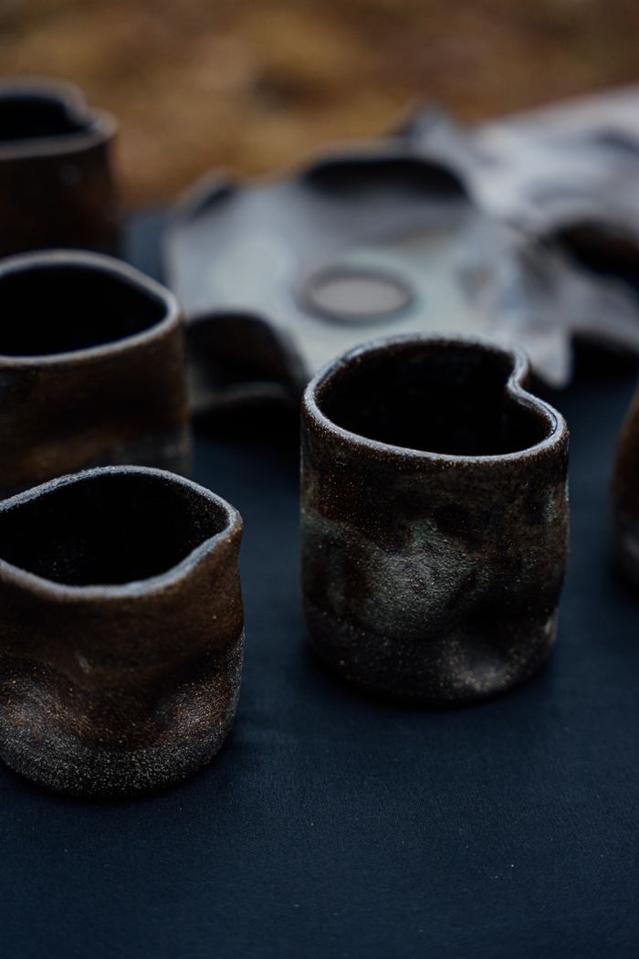 Close-up of rustic handmade ceramic mugs showcasing unique textures and earthy tones.
